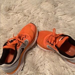 Orange black and white women’s Nike tennis shoes